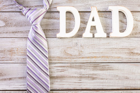White letters DAD on a painted wood background.