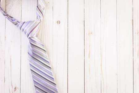 Striped men's tie on a wood background.の写真素材