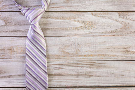 Striped men's tie on a wood background.の写真素材
