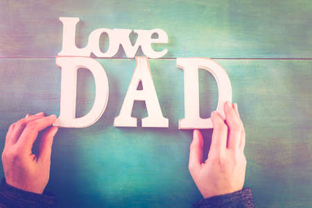 White letters DAD on a painted wood background.の写真素材