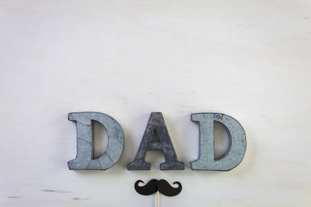 Metal letters DAD on a painted wood background.の写真素材