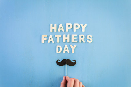 Unfinished wood lettrs sign Happy Father's Day on a painted wood background.の写真素材