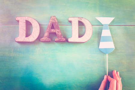 Metal letters DAD on a painted wood background.の写真素材