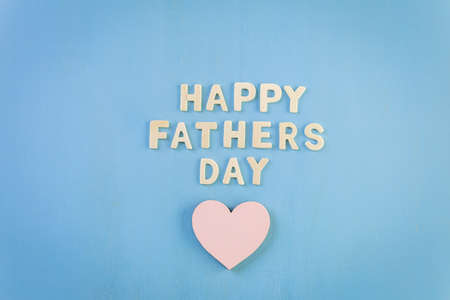 Unfinished wood lettrs sign Happy Father's Day on a painted wood background.の写真素材