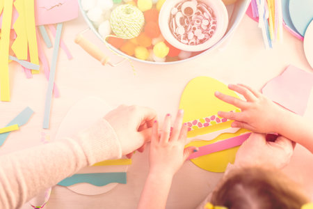 Step by step. Mother and daughter decorating paper Easter eggs.の写真素材