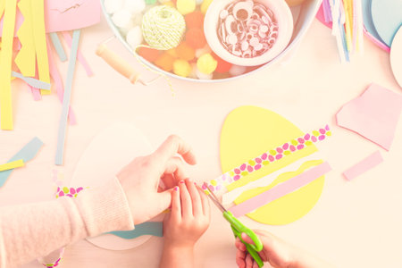 Step by step. Mother and daughter decorating paper Easter eggs.の写真素材