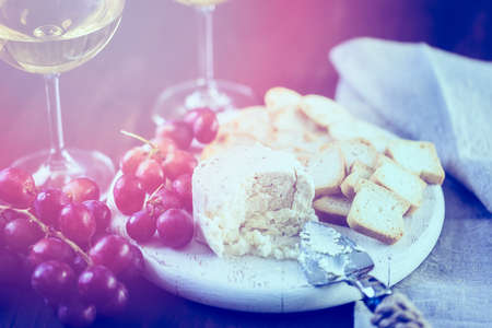 Soft flavored creamy cheese with garlic and fine herbs on a wood board with crackers.の写真素材