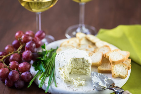 Soft flavored creamy cheese with garlic and fine herbs on a wood board with crackers.の写真素材
