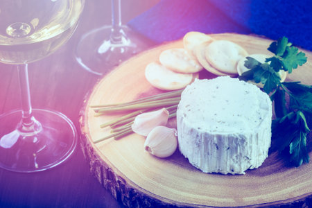 Soft flavored creamy cheese with garlic and fine herbs on a wood board with crackers.の写真素材
