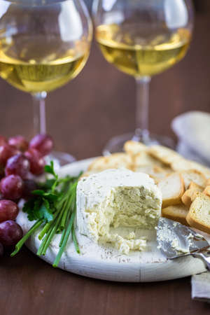 Soft flavored creamy cheese with garlic and fine herbs on a wood board with crackers.の写真素材