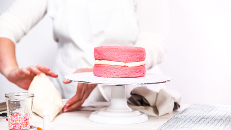 Step by step. Stacking layers together of pink birthday cake.