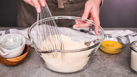 Step by step. Mixing ingredients together in glass mixing bowl for spicy jalapeno cornbread muffins.