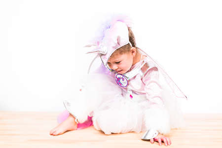 Portrait of a little girl in glitter unicorn costume on a white background.の写真素材