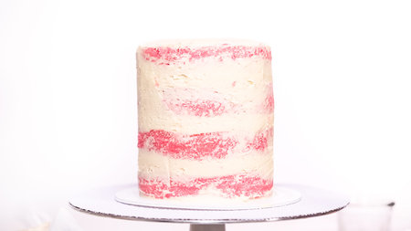 Step by step. Icing tall birthday cake with white buttercream icing.