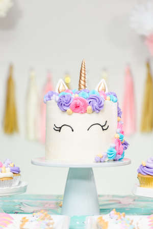 Little girl birthday party table with unicorn cake, cupcakes, and sugaer cookies.の写真素材