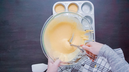 Step by step. Top view. Filling metal muffin pan with cornbread batter.の写真素材