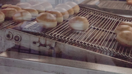 Industrial production of donuts by machine.