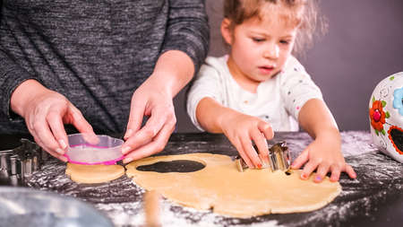 Mother and daughter baking sugar skull cookies for Dia de los Muertos holiday.の写真素材