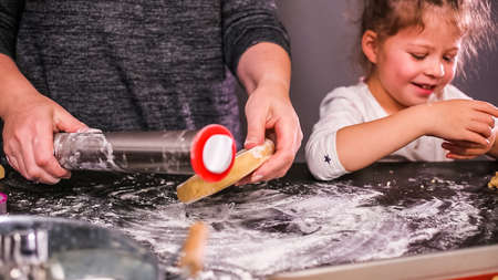 Mother and daughter baking sugar skull cookies for  holiday.の写真素材