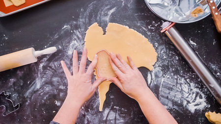 Flat lay. Woman baking sugar skull cookies for Dia de los Muertos holiday.