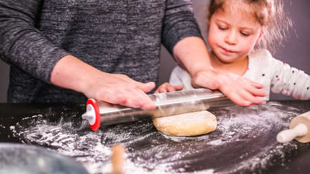 Mother and daughter baking sugar skull cookies for  holiday.の写真素材