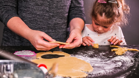 Mother and daughter baking sugar skull cookies for  holiday.の写真素材