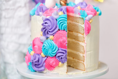 Sliced multilayer unicorn cake on cake stand at the little girl birthday party.の写真素材