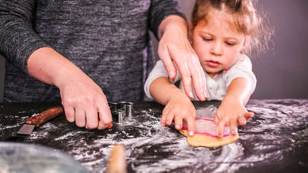 Mother and daughter baking sugar skull cookies for  holiday.の写真素材