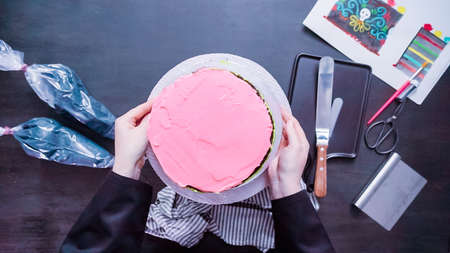 Baker frosting multi layer chocolate cake with buttercream frosting.の写真素材
