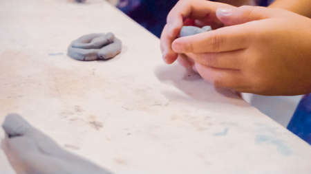 Little girls creating small kids sculptures from clay.の写真素材