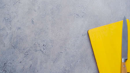 Yellow wood cutting board and knife on the table.の写真素材