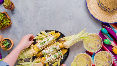Mexican corn on the cob Elote garnished with spices and fresh cilantro.の写真素材