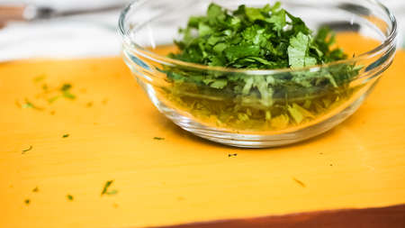 Chopping cilantro on wood cutting board.の写真素材