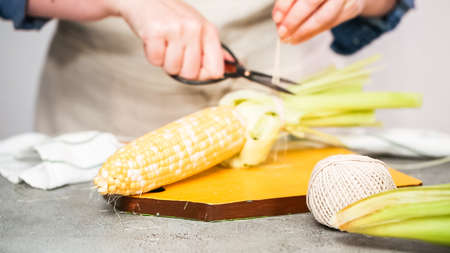 Shucking organic corn to make Mexican corn on the cob Elote.の写真素材