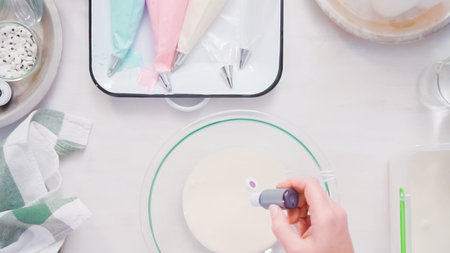 Mixing food coloring into royal icing to decorate unicorn sugar cookies.