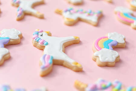 Unicorn sugar cookies decorated with royal icing on a pink  background.の写真素材