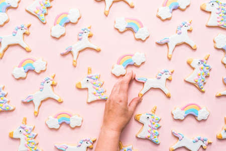 Unicorn sugar cookies decorated with royal icing on a pink  background.の写真素材