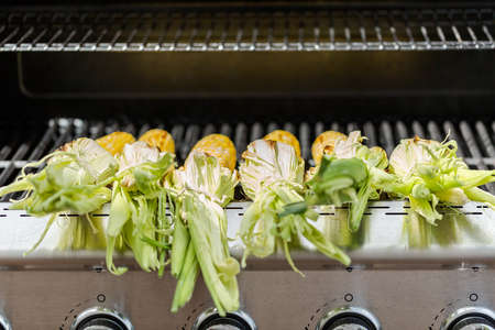 Grilling mexican street corn elote on outdoor gas grill.の写真素材