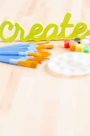 Green create sign with paint brushes on the table.の写真素材