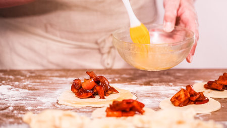 Step by step. Making home made empanadas with red apples fillings.