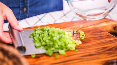 Step by step. Slicing green onions on a wood cutting board.の写真素材