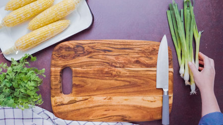 Step by step. Empty wood cutting board with a large kitchen knife.
