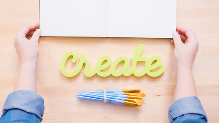 Green create sign with paint brushes on the table.