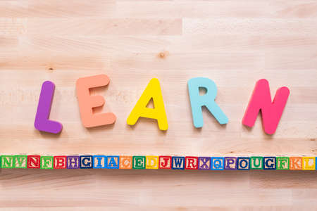 Bright color wooden LEARN sign on wood desk.の写真素材