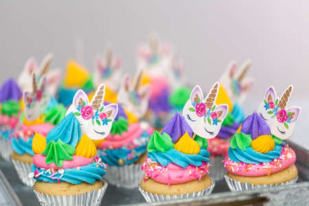 Unicorn cupcakes with multicolor buttercream icing on metal tray.の写真素材