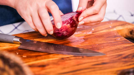 Step by step. Slicing purple onion on a wood cutting board.の写真素材
