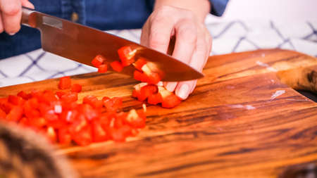 Step by step. Slicing red bell pepper on a wood cutting board.の写真素材