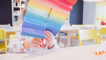 Little girl making paper butterflies from multicolor paper.の写真素材