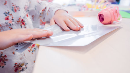 Little girl making paper butterflies from multicolor paper.の写真素材