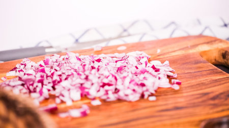 Step by step. Slicing purple onion on a wood cutting board.